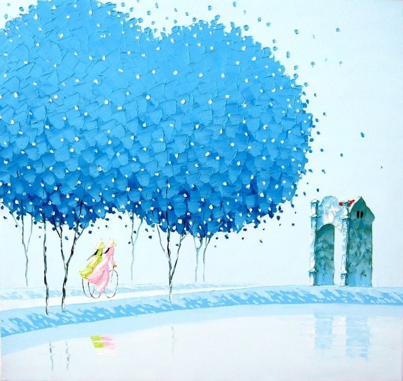 Hàng cây tán xanh lơ, hai cô gái áo dài đạp xe, cổng làng nhỏ ở bên phải phản chiếu xuống mặt nước