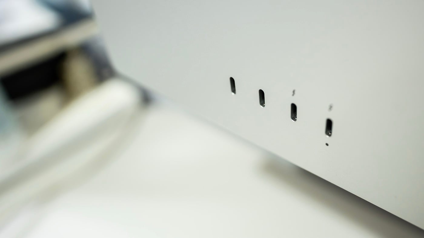 Cận cảnh cạnh dưới mặt sau màn hình màu bạc với bốn cổng USB-C và Thunderbolt xếp hàng ngang