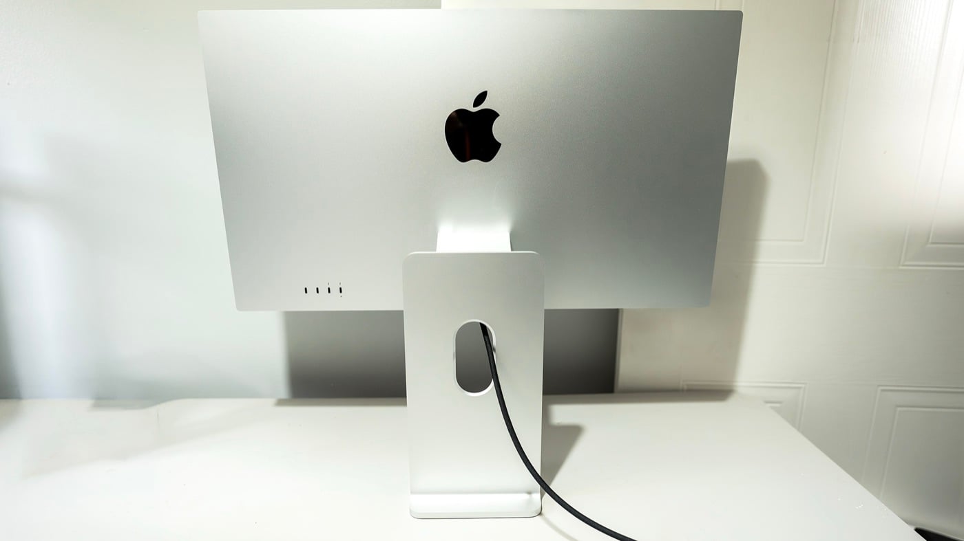 Mặt sau màn hình Apple Studio Display XDR màu bạc trên chân đế nhôm, có lỗ luồn dây ở chân đế