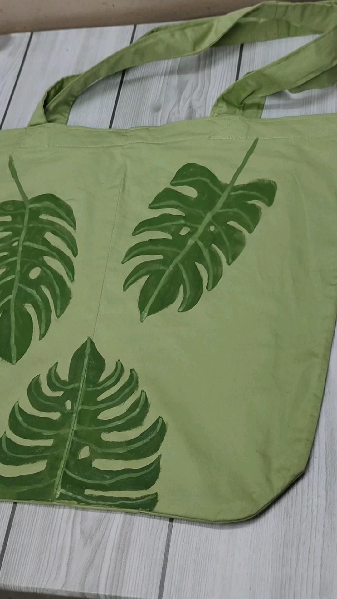 Túi tote vải xanh lá nhạt vẽ ba chiếc lá monstera màu xanh đậm bằng acrylic