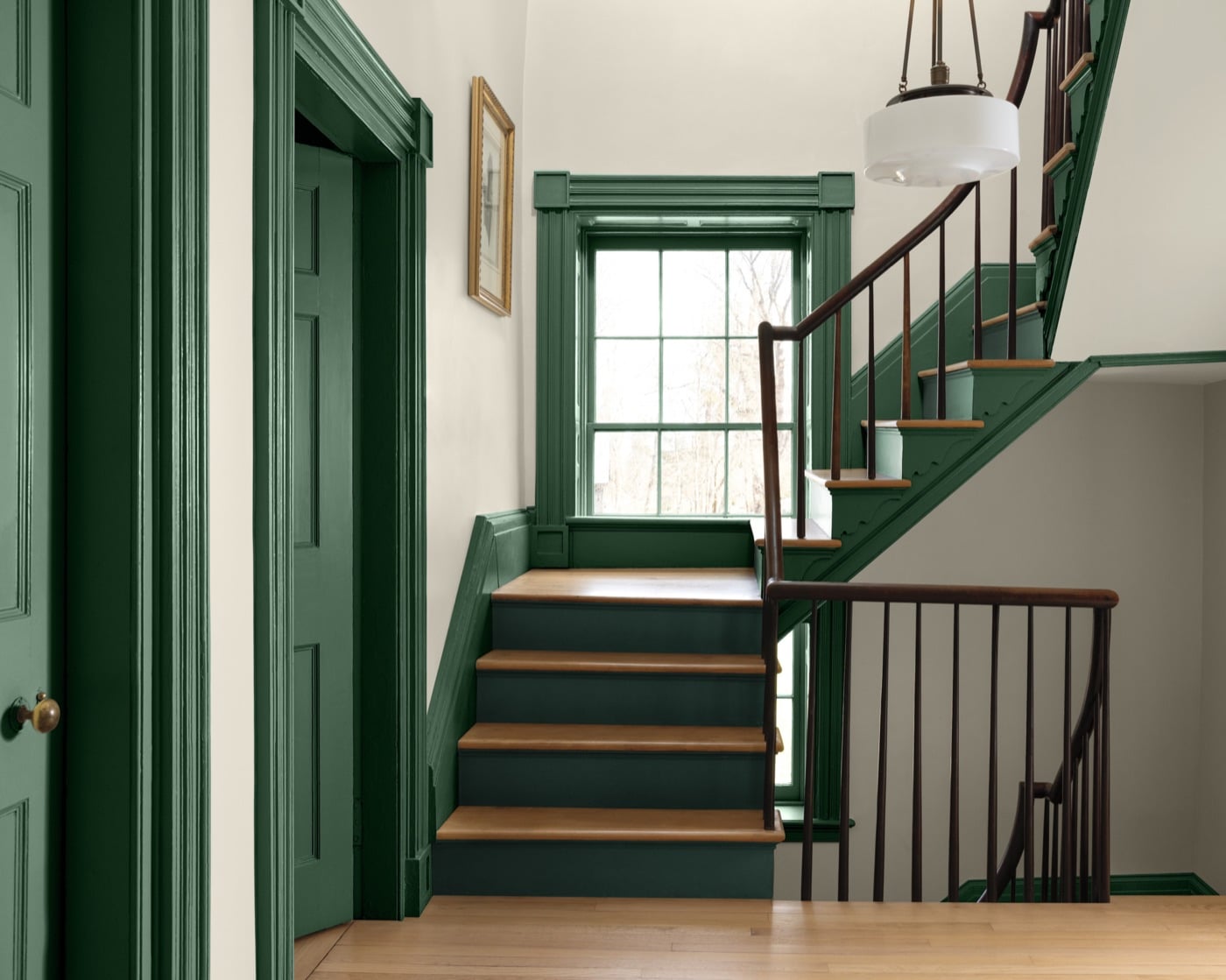 Cầu thang gỗ trong nhà với cửa và nẹp sơn xanh lá Webster Green, tường trắng, cửa sổ nhiều ô kính