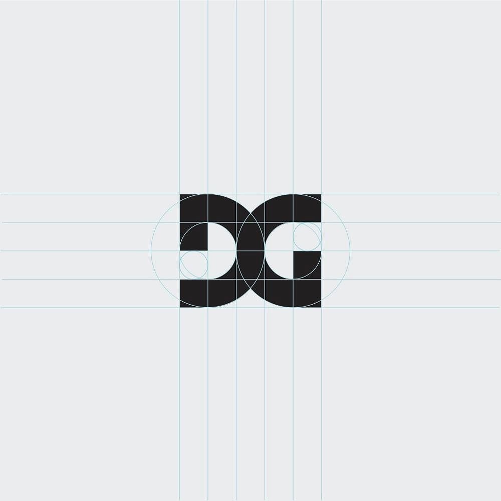 Logo DG khối đen dựng trên lưới và các vòng tròn, chữ D và chữ G đứng sát nhau