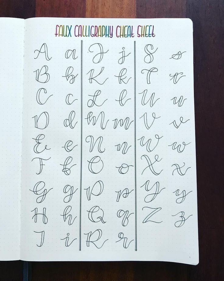 Bảng chữ cái faux calligraphy viết tay trên sổ chấm, nét xuống được tô đôi thành nét đậm rỗng ruột, tiêu đề nhiều màu ở trên
