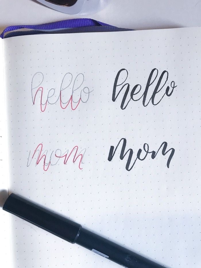 Hai chữ hello và mom viết hai lần: bản phác bút chì có nét đỏ đánh dấu chỗ kéo dài, bên cạnh là bản bounce lettering hoàn thiện bằng bút đen