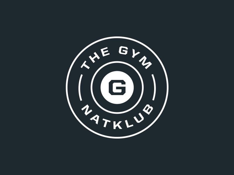 Logo The Gym dạng huy hiệu tròn, chữ chạy vòng quanh chữ G ở giữa, nét trắng trên nền xanh than