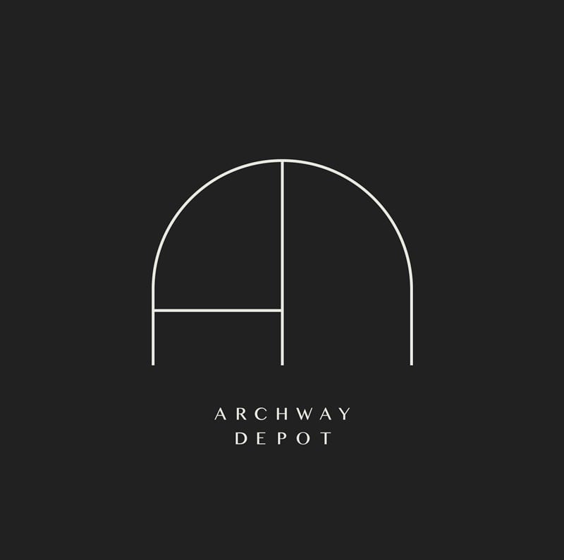 Logo Archway Depot: cửa vòm nét mảnh màu kem trên nền đen, bên trong ẩn chữ A và D