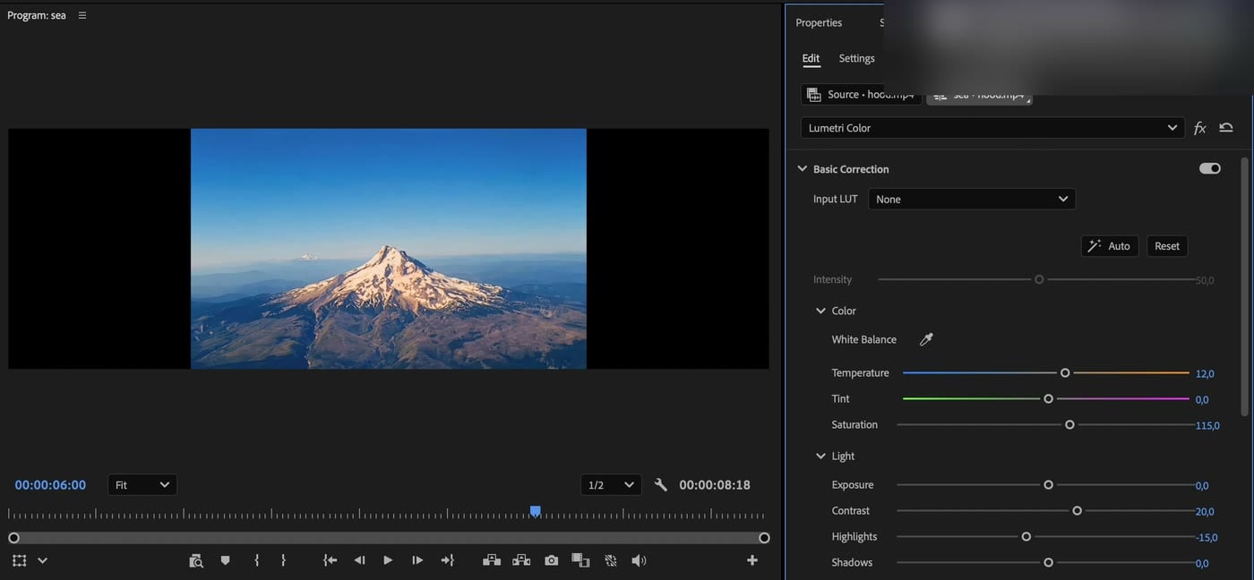 Lumetri Color Basic Correction trong panel Properties của Premiere 2026: Temperature 12, Saturation 115, Contrast 20, Highlights -15 trên video núi