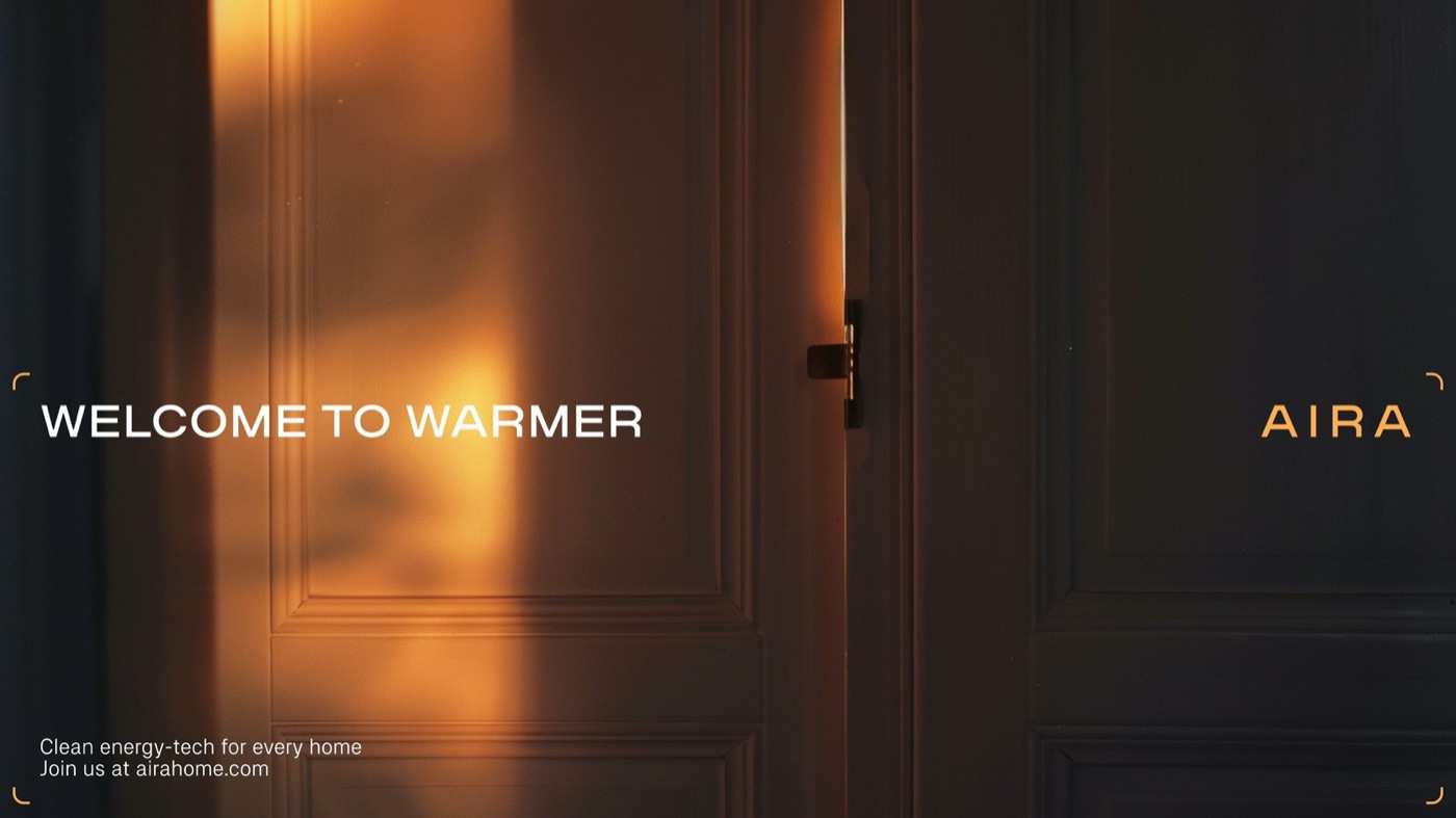 Ảnh cánh cửa gỗ sơn tối, một vệt nắng cam ấm chiếu qua khe cửa, dòng chữ WELCOME TO WARMER màu trắng bên trái và logo chữ AIRA màu cam trong khung ngoặc vuông bên phải