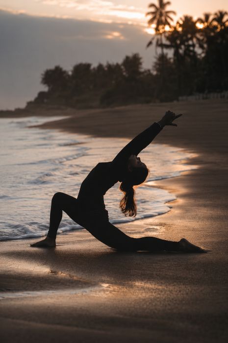 Hình ảnh người phụ nữ tập yoga trên bãi biển vào hoàng hôn